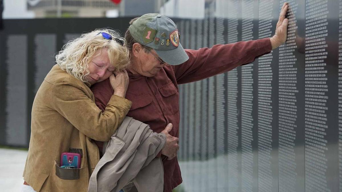 
Lisa McCann (left) of Excelsior Springs comforted a friend, Army veteran Michael Connelly of Smithville, who recognized the names of comrades killed in Cambodia during the Vietnam War. 
