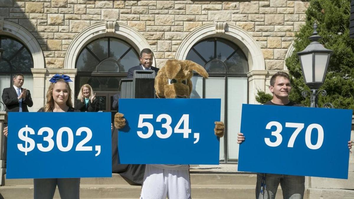 Cheer squad members Kylie Rifkin (left), school mascot Kassey Roo, and Austin Hass held up the numbers $302,534,370 — the amount the University of Missouri-Kansas City raised over seven years in private contributions for capital projects, faculty support and scholarships.