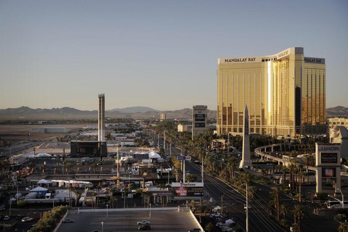 The Mandalay Bay resort and casino, right, overlooks an outdoor festival grounds across the street, left, on Tuesday Tuesday. Authorities said Stephen Craig Paddock broke the windows on the casino and began firing with a cache of weapons, killing dozens and injuring hundreds at a music festival at the grounds.