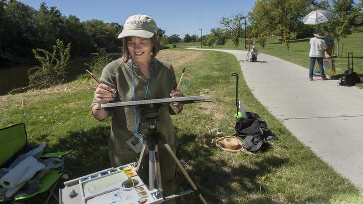 
Dozens of artists, including Candace Castle of St. Joseph (foreground) and Louanne Hein of Kansas City (under umbrella), participated Saturday in the Brush Creek Art Walk. The event continues Sunday.
