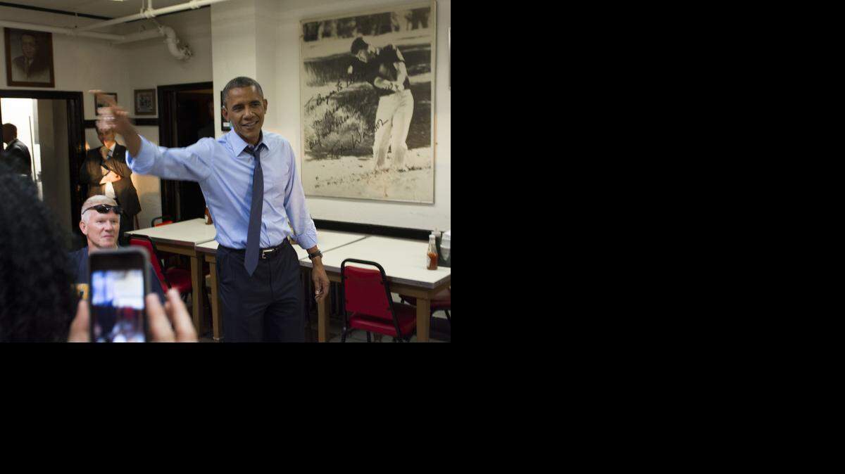 
President Barack Obama waved as he walked in to meet with residents of the city at Arthur Bryants Barbecue while waiting for his order during a visit to Kansas City on Tuesday, July 29, 2014, in Kansas City, Missouri.
