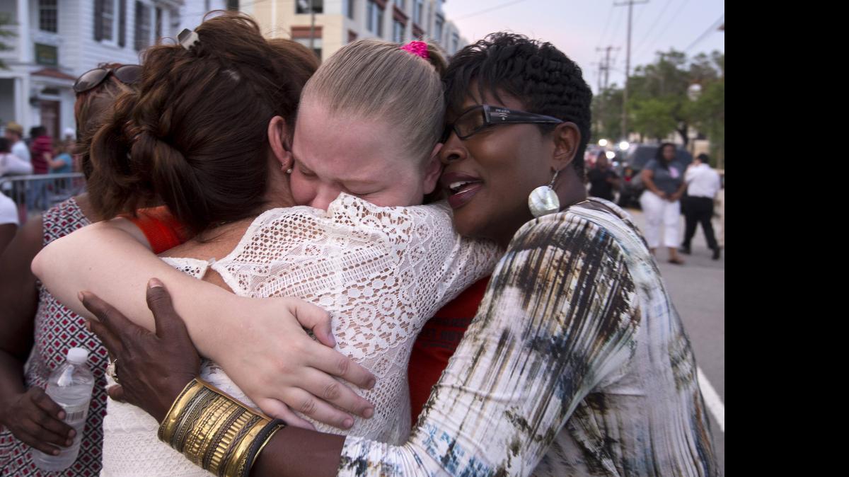 
J. Denise Cromwell, left, hugs her daughter, Asia Cromwell, center, and a friend Sandy Teckledburg outside the Emanuel AME Church, Friday, June 19, 2015, after a memorial in Charleston, S.C. Thousands gathered at the College of Charleston TD Arena to bring the community together after nine people where shot to death at the church on Wednesday. 
