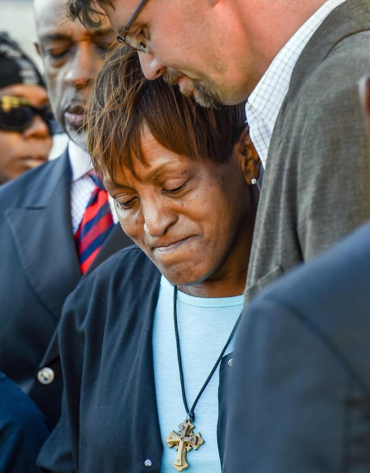 Narene Stokes-James received a hug from the Rev. Eric Garbison during a prayer vigil for her son Ryan Stokes on Wednesday at the corner of 12th and McGee streets. The Southern Christian Leadership Conference of Greater Kansas City has asked the U.S. attorney general’s office and the FBI to investigate the shooting. A grand jury declined to indict the officer who shot Stokes.