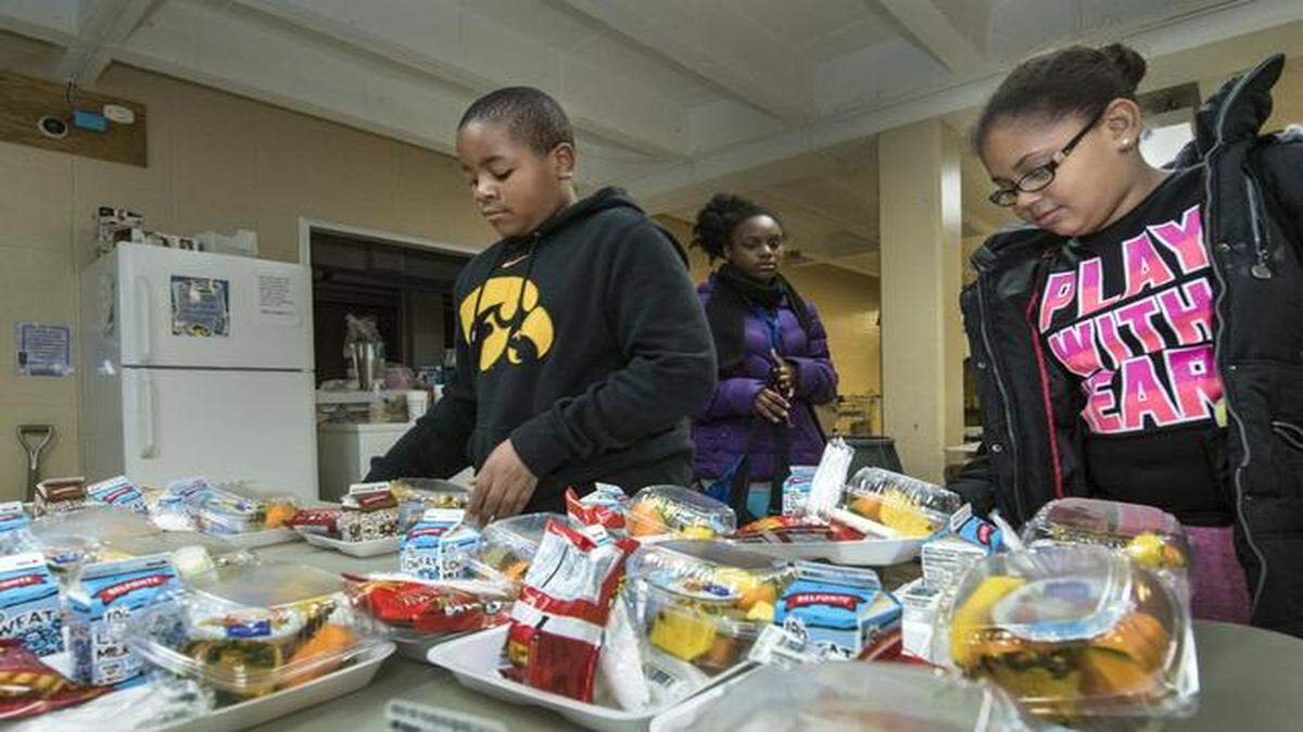 
After school, the Police Athletic League provides students like Da’Quan Brown (from left), 10, Makayla Green and Kiera Johnson, both 11, with small meals.
