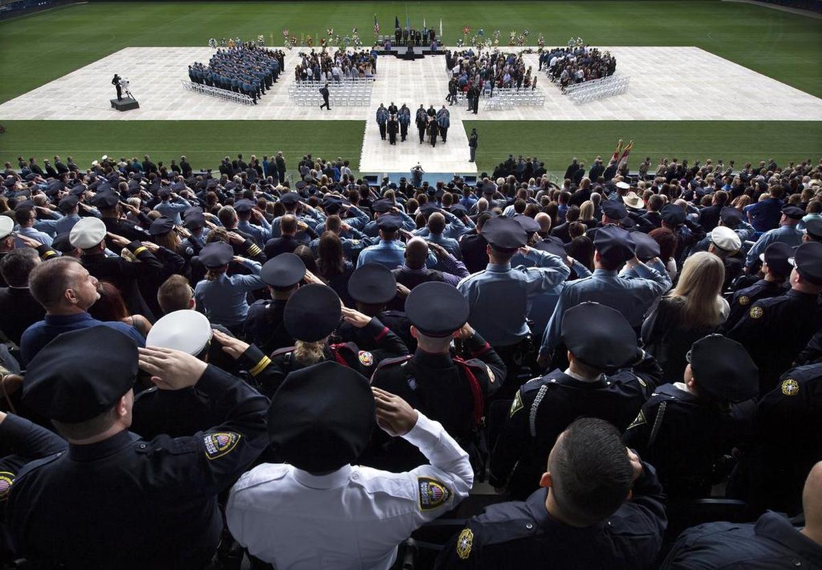 The caskets of Wyandotte County deputies Theresa King (left) and Patrick Rohrer were escorted from the field following their funeral on Thursday, June 21, 2018, at Children’s Mercy Park in Kansas City, Kan.