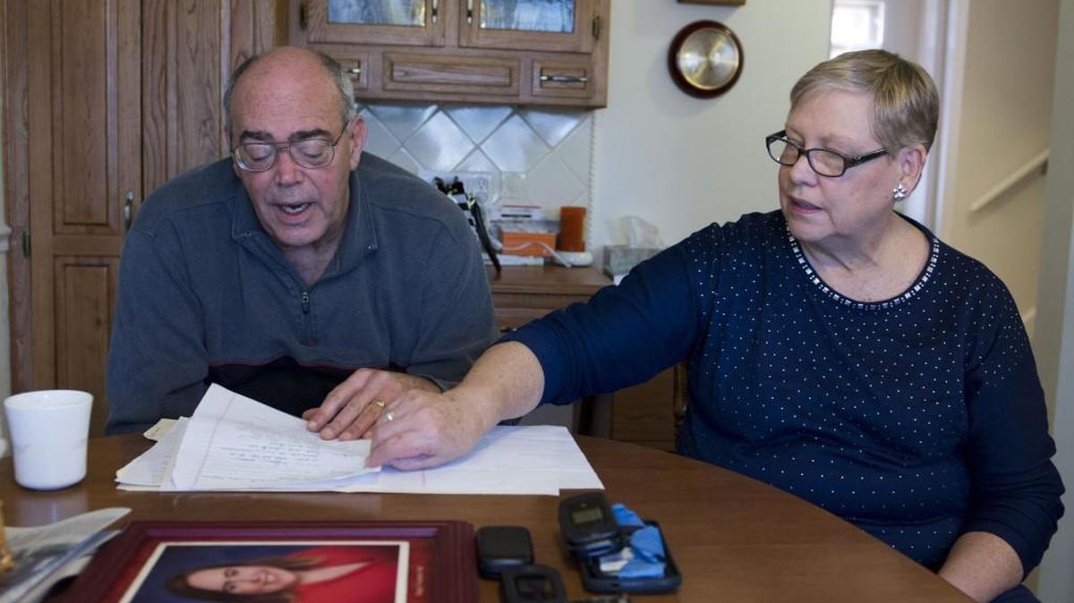 Leafing through records of their family’s ordeal, Maurice (left) and Gloria Bowersox of Olathe explained how a con man took advantage of their 33-year-old daughter, who has schizophrenia.