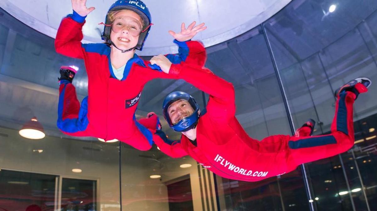 At an iFly outside Houston, an instructor helps a child learn to navigate a wind tunnel similar to one soon to open in Overland Park.