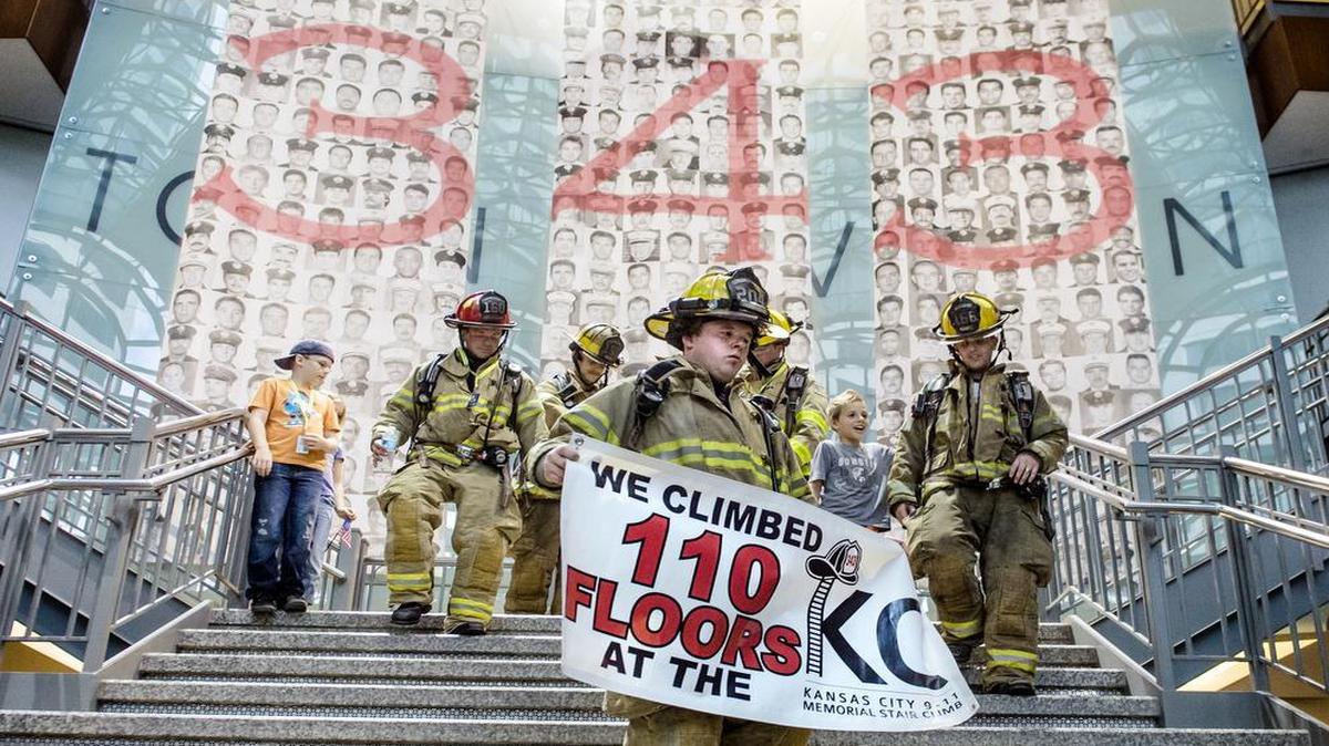 
Timothy Morris, a firefighter from Hutchinson, held a banner that he and his fellow firefighters posed for photos with after finishing the Kansas City Memorial Star Climb on Sunday in the Town Pavilion building in downtown Kansas City. Hundreds of firefighters from eight states climbed a total of 110 stories, commemorating the number of New York firefighters killed in the 9-11 terrorist attack on the World Trade Center and the height of New York’s twin towers.
