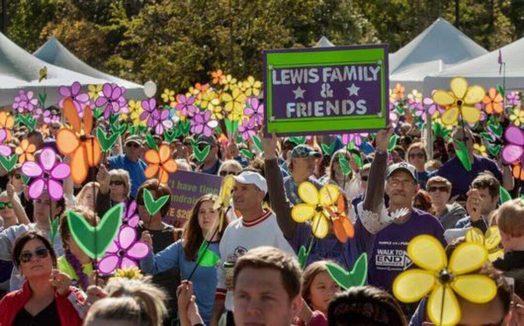 
A crowd of more than 5,000 raised their Promise Garden flowers before the start of the 26th annual Walk to End Alzheimer’s on Sunday at Corporate Woods in Overland Park. 

