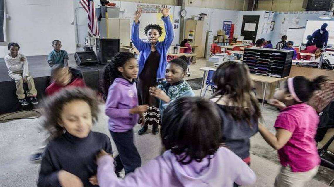 
Domonique Jones (back, in blue) led her third- and fourth-grade students in a game of “Mingle, Mingle, Mingle” at the Academy for Integrated Arts charter school in Kansas City. The students run around until Jones holds up a number, and the children must form groups of that number before time runs out. The school, which opened in 2012, is operating in renovated commercial space on Troost Avenue. 
