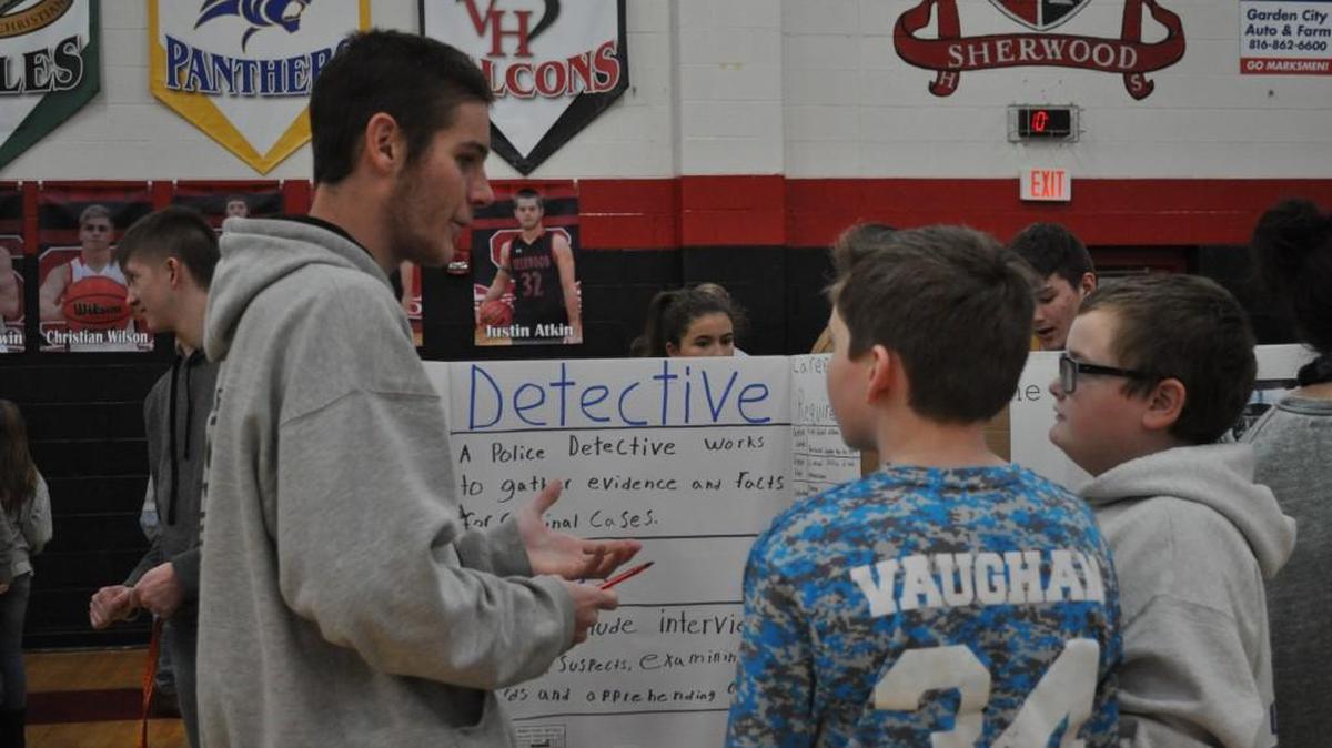 Sherwood High School student Shawn Grew talked about being a detective with sixth-grade students Dustin Vaughn and Jaxon Harris.