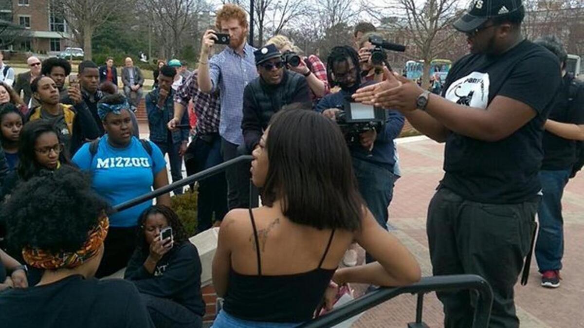 Marshall Allen, one of the original members of Concerned Student 1950, speaks to students gathered in Traditions Plaza Monday afternoon as filmmaker Spike Lee looks on. The group staged a lunchtime rally Monday on the University of Missouri campus in Columbia.