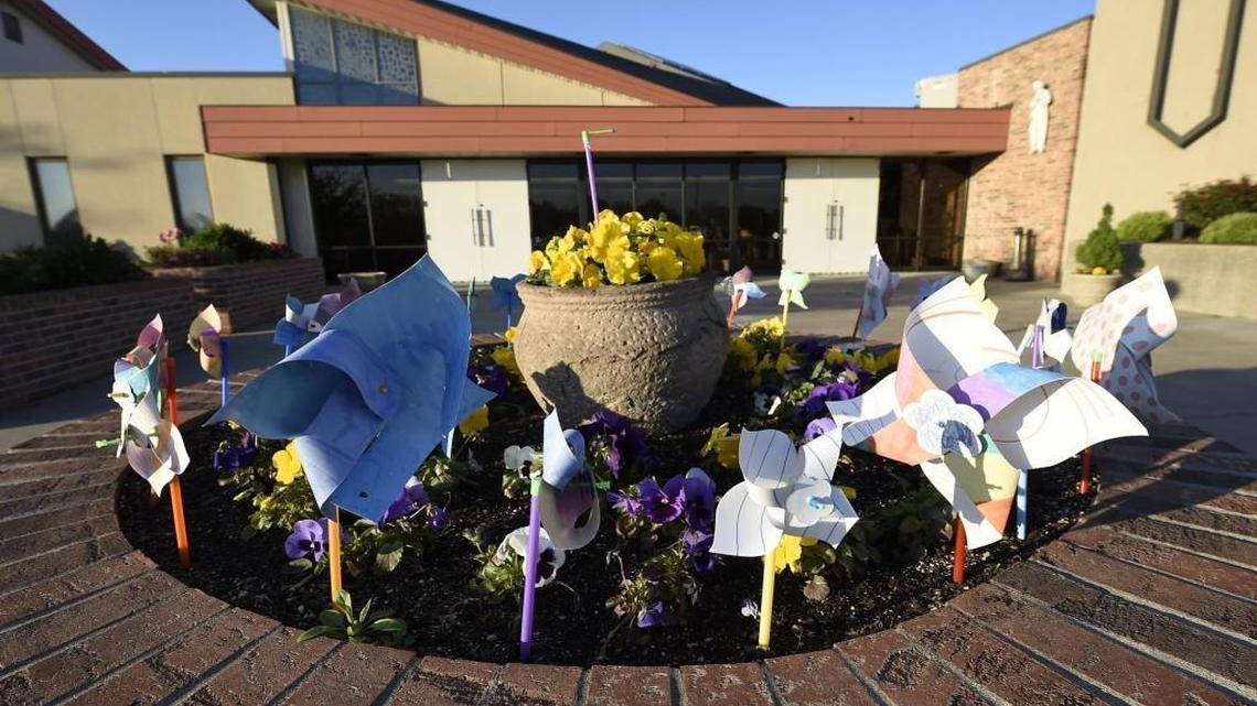 Pinwheels symbolizing the healing process adorn a planter just outside the entrance to St. James Catholic Church, where Bishop James V. Johnston Jr. recently held a service for spiritual healing.