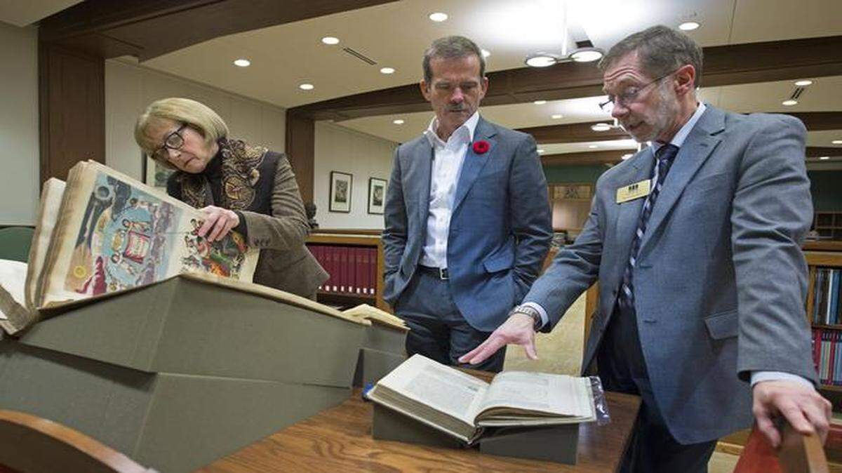 
Lisa Browar, president of the Linda Hall Library, looked on as Chris Hadfield (center), commander of the International Space Station, viewed rare books written by Newton, Galileo and Cellarius with Bruce Bradley, librarian for history of science, during a visit to the library Tuesday. Hadfield was in town for a book signing and reception at the library.
