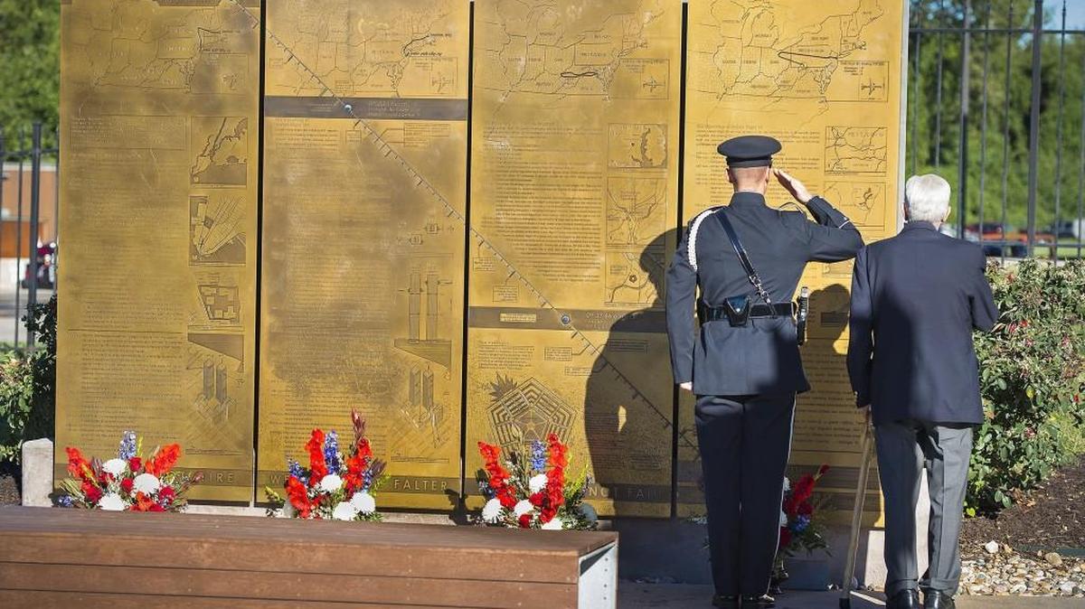 Overland Park Police Officer Trenton Gunter (left) saluted after escorting Harvey Bodker of Overland Park and placing a wreath at the base of the bronze plaques at Overland Park’s 9/11 Memorial on Sept. 11 last year.