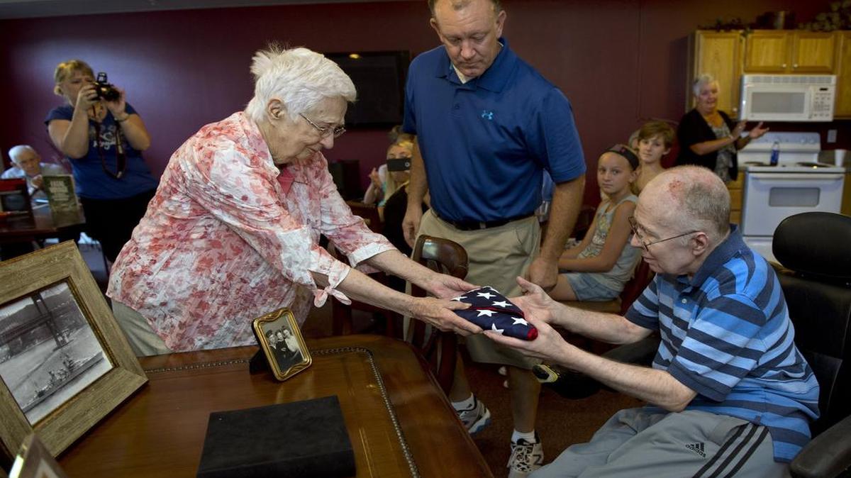 
Harriett Watson handed a flag that flew this week at the USS Indianapolis memorial to her son, Bob Batson. Watson's husband Eugene Batson died when the ship was sunk by the Japanese in July 1945. Brad Newland (center) delivered the flag from Indiana to Kansas City.
