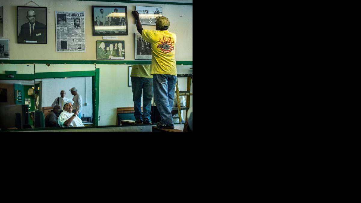 
On Monday afternoon inside the Green Duck Lounge and Grill, Bruce Watkins Jr. (lower center) watched Walter Allen hang historical photos of Leon Jordan and others. 

 
