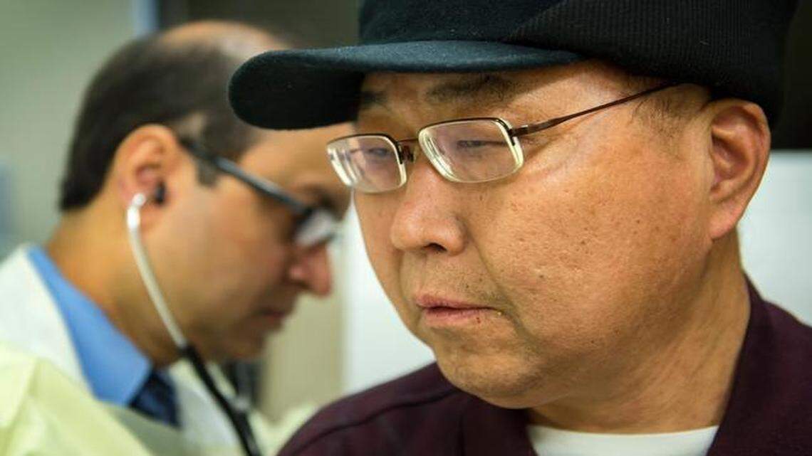
David Jiang was in danger of losing vision in his left eye when his eye specialist tracked down the inventor of a tiny eye implant that releases an anti-viral drug. Jiang was examined recently by Siddhartha Ganguly (left) at the University of Kansas Cancer Center.
