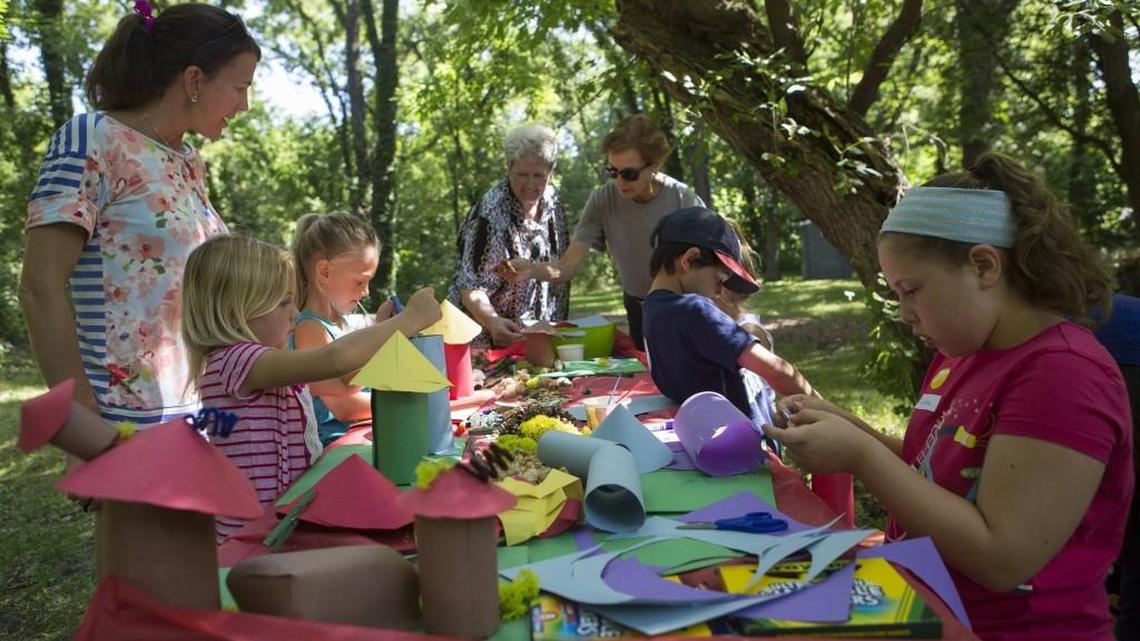 Kristen Hilgers (left), Grace Johnson, Every Hilgers, Betsy Harlan, Pat Griggs, Claire Solis and Lydia Solis worked around the crafts table during a “build your own gnome house” children’s class in the Enchanted Forest at the Overland Park Arboretum and Botanical Gardens.