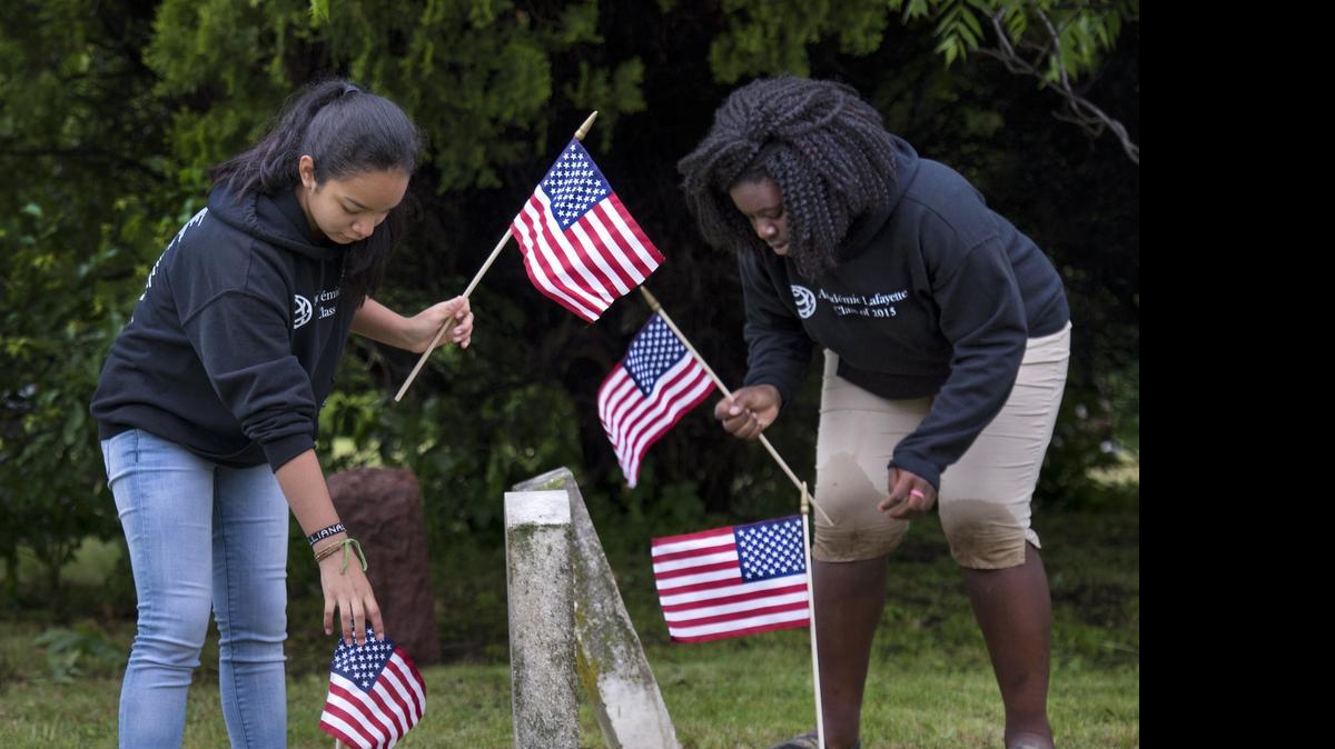 
After cleaning headstones with toothbrushes, Academie Lafayette students Liliana Reyes (left) and Kayla Civil placed flags Wednesday at the graves of military veterans at Highland Cemetery. The site near 19th Street and Blue Ridge Boulevard originated as a segregated black cemetery from Kansas City’s early days. Students from the charter school have been instrumental in helping get the long-neglected cemetery spruced up for Memorial Day.


