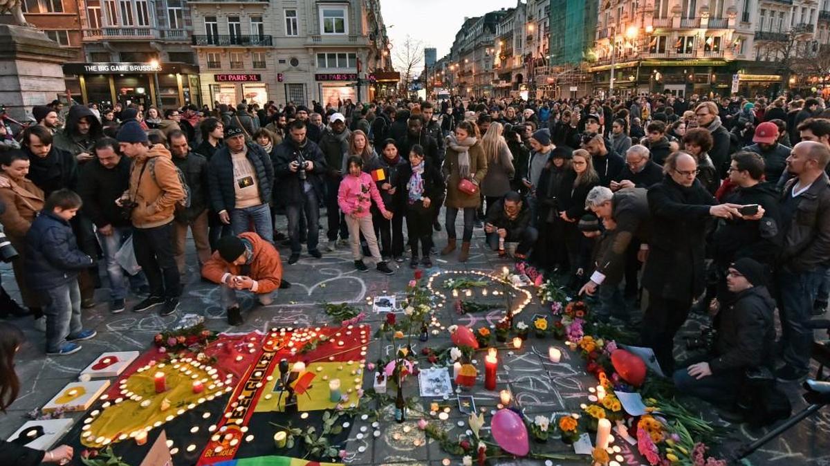 People brought flowers and candles to mourn Tuesday at the Place de la Bourse in the center of Brussels.