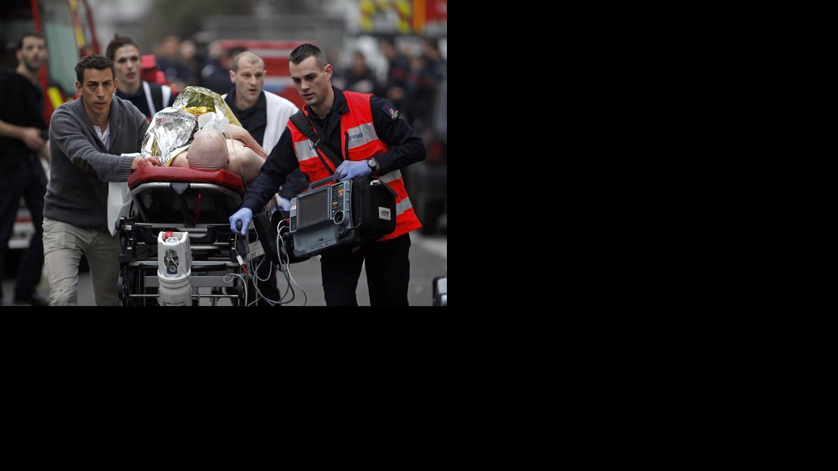 
An injured person is evacuated outside the French satirical newspaper Charlie Hebdo's office, in Paris, Wednesday.
