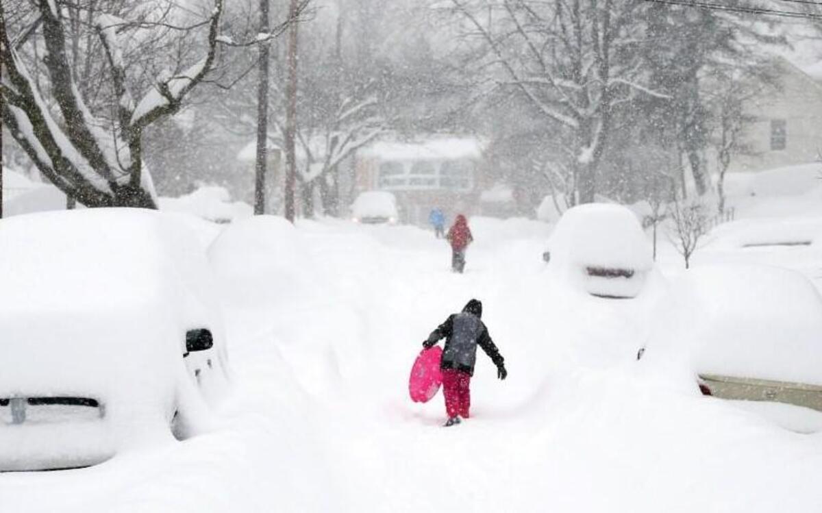 Children climb a hilly, snow-covered street with their sleds Saturday in Winchester, Va., where more than 16 inches of snow had fallen by early afternoon.