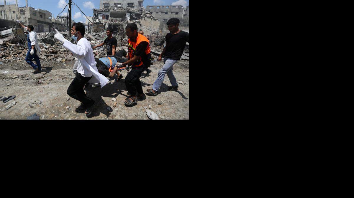
Israel said that its troops moving toward the Shuja’iya neighborhood of Gaza City encountered “intense resistance” from Hamas gunmen. Palestinian medics carried an injured man from the neighborhood on Sunday.
