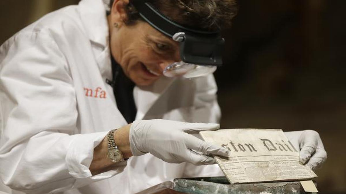 
Museum of Fine Arts Boston Head of Objects Conservation Pam Hatchfield removes a folded 19th century newspaper from a time capsule at the museum, Tuesday
