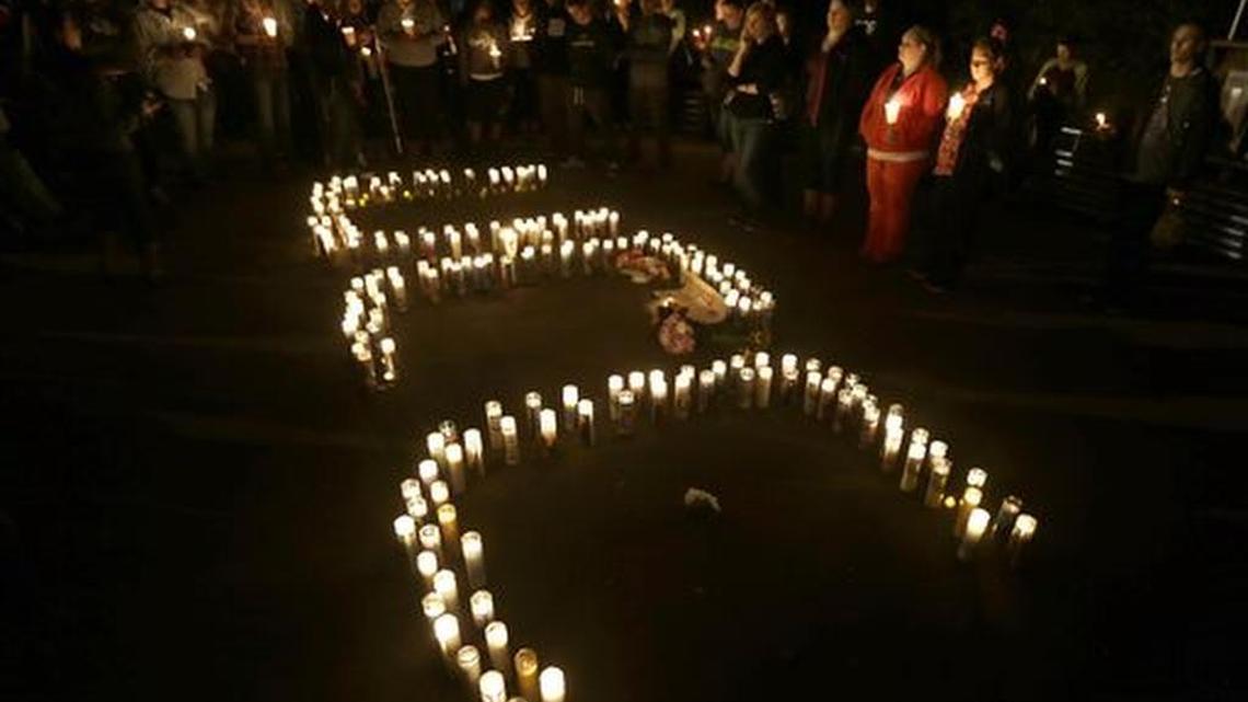 Candles spelling UCC for Umpqua Community College, are displayed at a candlelight vigil for those killed during a fatal shooting at the school, Thursday, Oct. 1, 2015, in Roseburg, Ore.