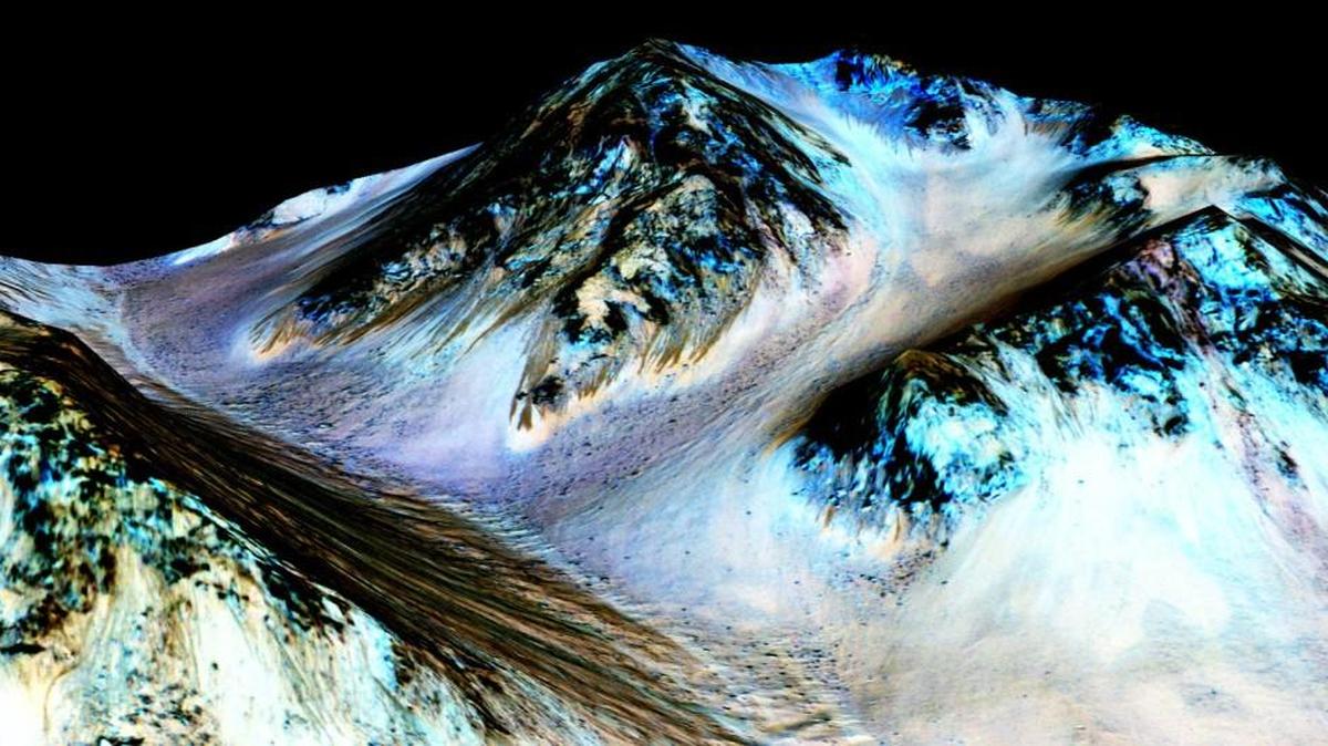 
This undated photo provided by NASA and taken by an instrument aboard the agency’s Mars Reconnaissance Orbiter shows dark, narrow, 100 meter-long streaks on the surface of Mars that scientists believe were caused by flowing streams of salty water. 
