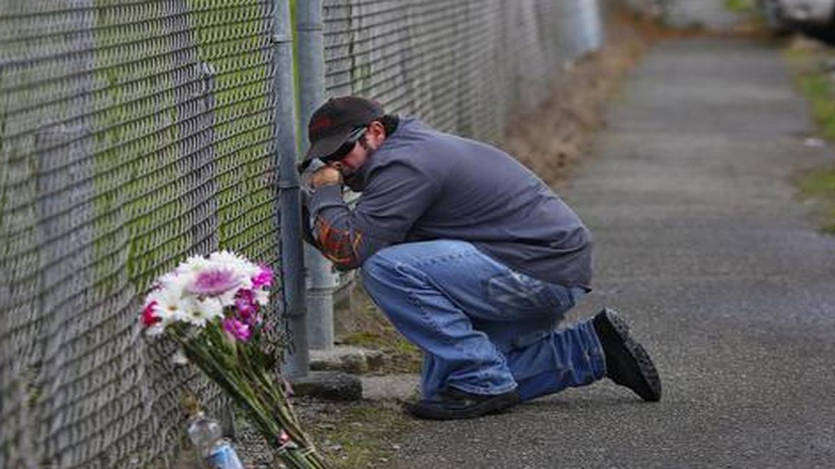 
Dale Zachry, who graduated from Marysville-Pilchuck High School in 1986, stopped for a prayer at the fence surrounding the school grounds in Marysville, Washington

