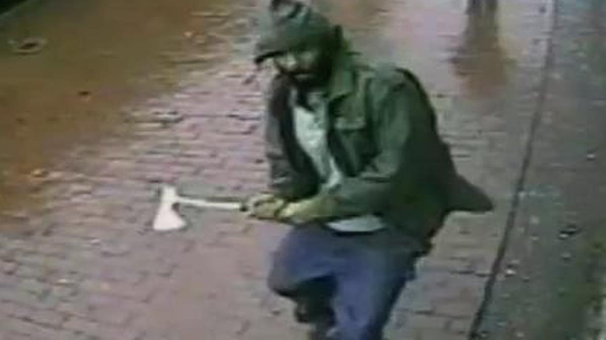 
In this frame grab taken from video provided by the New York Police Department, an unidentified man approaches New York City police officers with a hatchet
