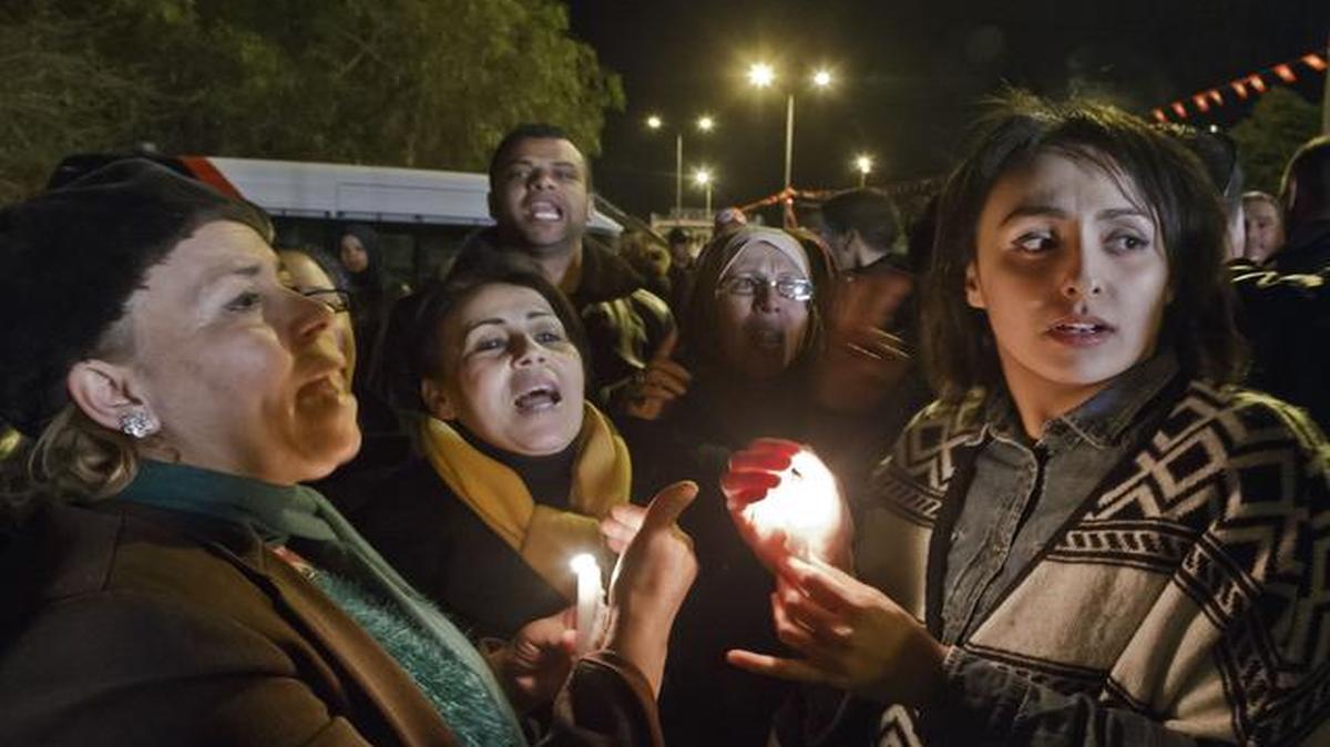 
Tunisians holding candles chant pro government slogans outside the National Bardo Museum where scores of people were killed after gunmen staged an attack, Tunis, Wednesday.
