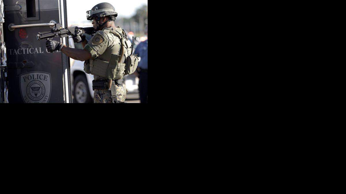 
A member of the St. Louis County Police Department points his weapon in the direction of a group of protesters in Ferguson, Mo. on Wednesday, Aug. 13, 2014. On Saturday, Aug. 9, 2014, a white police officer fatally shot Michael Brown, an unarmed black teenager, in the St. Louis suburb. (AP Photo/Jeff Roberson)

