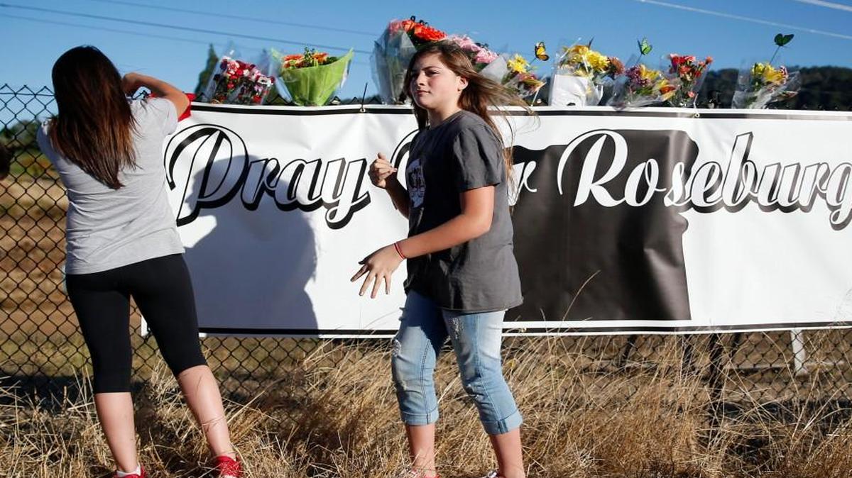 
Two girls placed mementos Friday at a makeshift memorial near the road that leads to Umpqua Community College in Roseburg, Ore., where a gunman killed nine persons before he was killed by authorities. 
