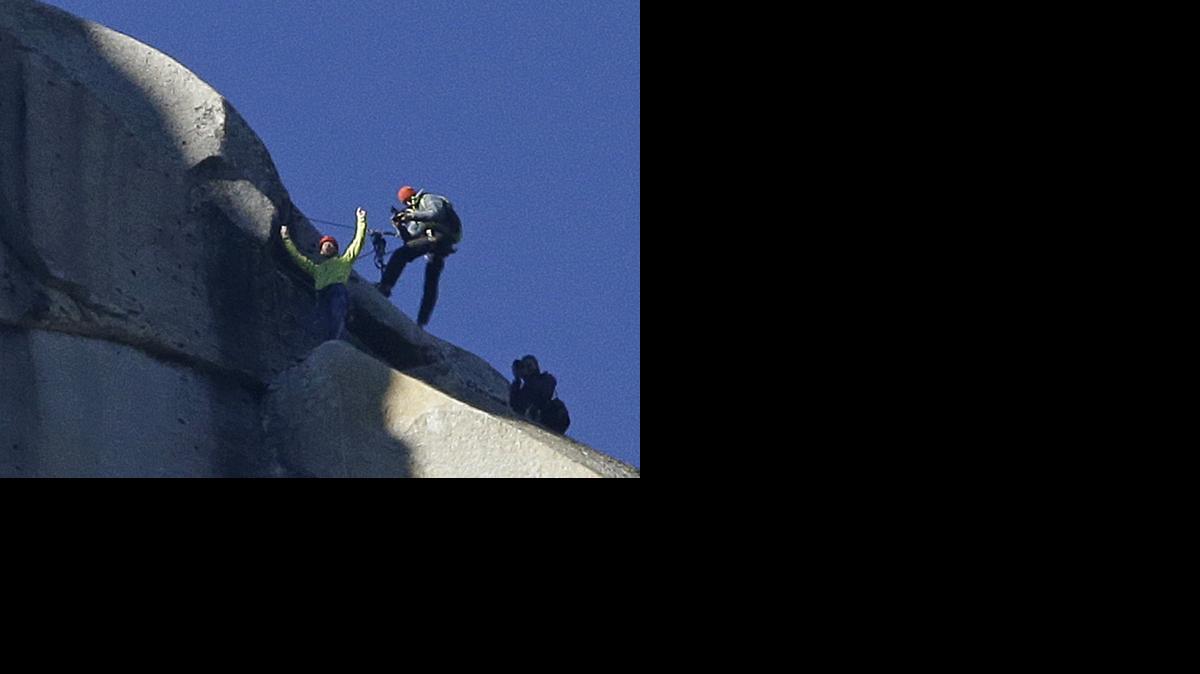 
Tommy Caldwell, top, raises his arms after reaching the summit of El Capitan, Wednesday in Yosemite National Park, Calif. Caldwell and Kevin Jorgeson became the first to free-climb the rock formation's Dawn Wall. 
