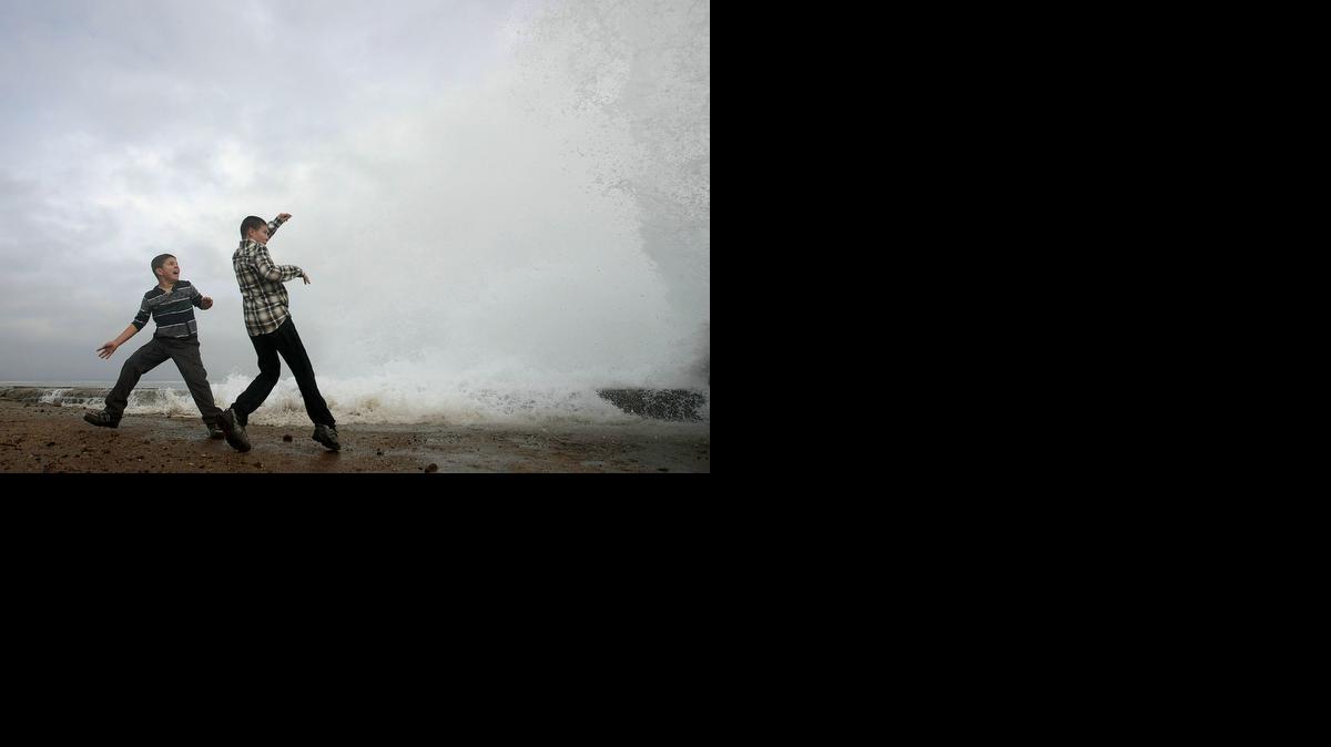 
Aidan Stephenson,12, and Conor Stephenson,10, visiting from Phoenix, watch the waves breaking on the rocks in Pacific Grove, Calif. 
