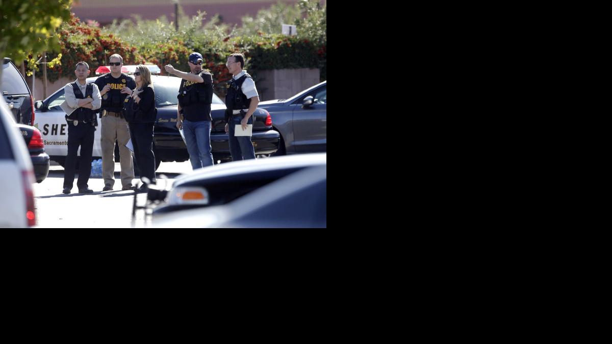 
Law enforcement officers gather at the site where a Sacramento County Sheriff's deputy was shot by an assailant who then carjacked two vehicles prompting a manhunt 
