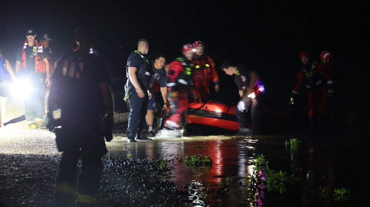 A woman whose boat overturned hung onto a tree branch for two hours before being rescued by Indianapolis firefighters.