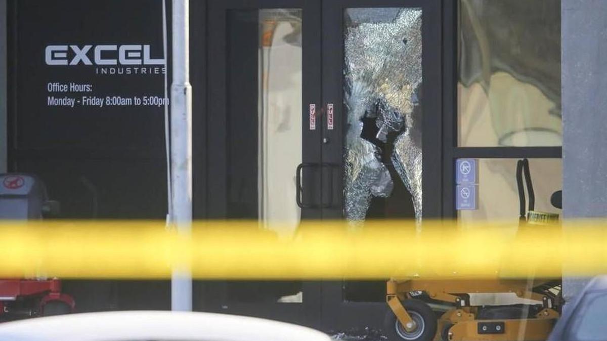 The main entrance of Excel Industries has a shattered window as investigators work inside the building Friday.
