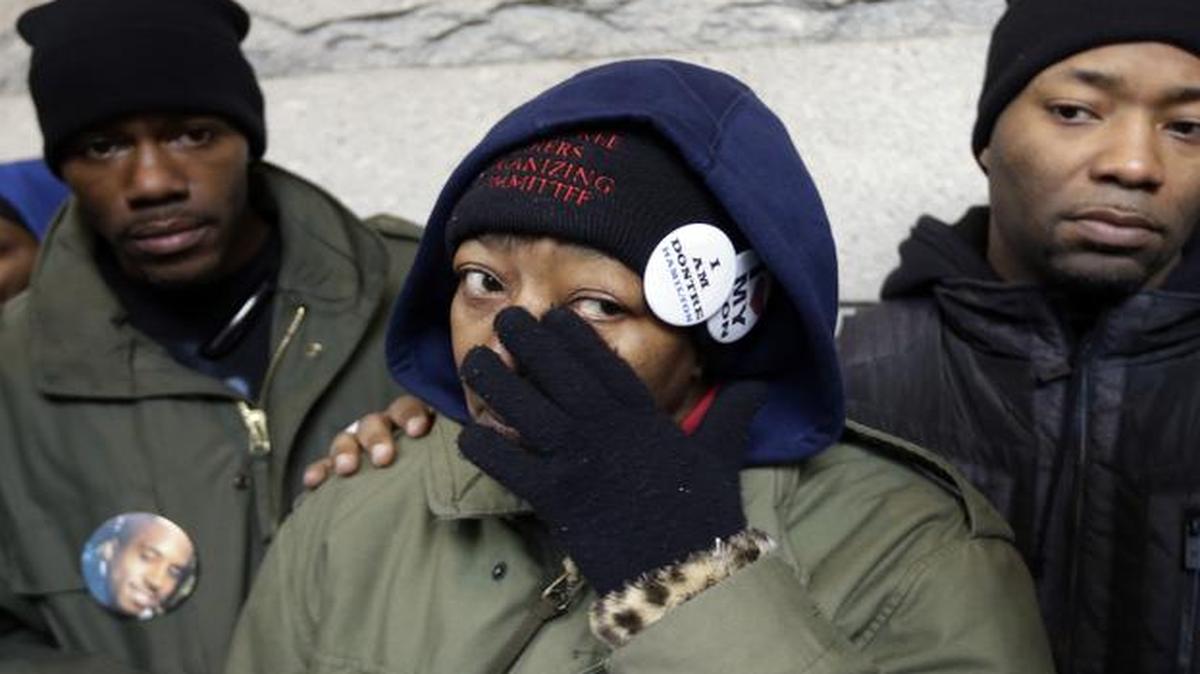 
Dontre Hamilton's mother, Maria Hamilton, wipes her eyes as she is is flanked by her sons Dameion Perkins, right, and Nate Hamilton on the steps on the federal courthouse Monday, Dec. 22, 2014, in Milwaukee. 

