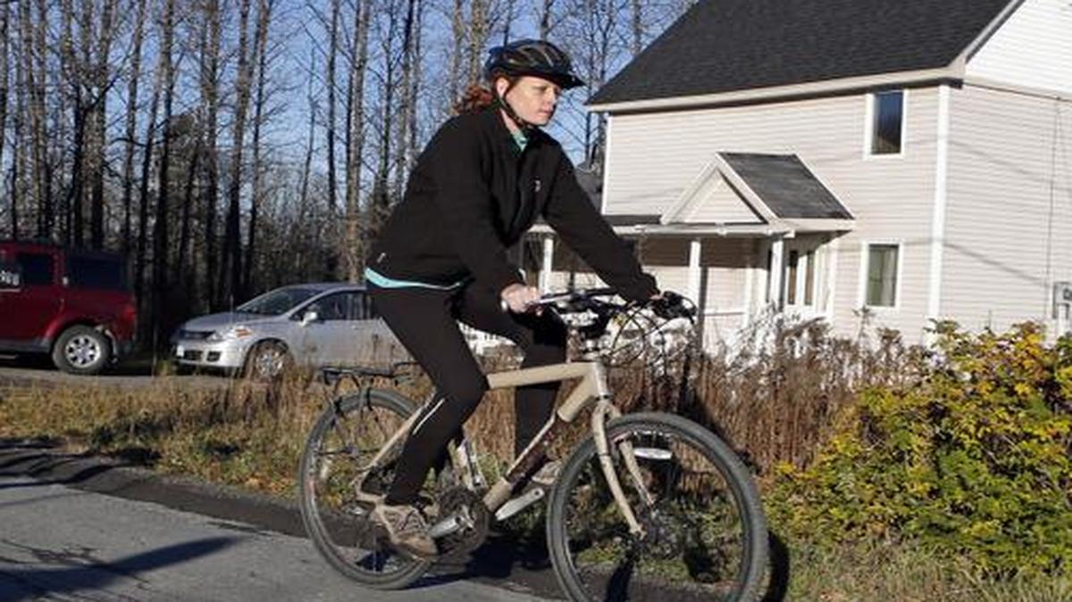 
Nurse Kaci Hickox rides away from the home she is staying in on a rural road in Fort Kent, Maine, to take a bike ride, Thursday,

