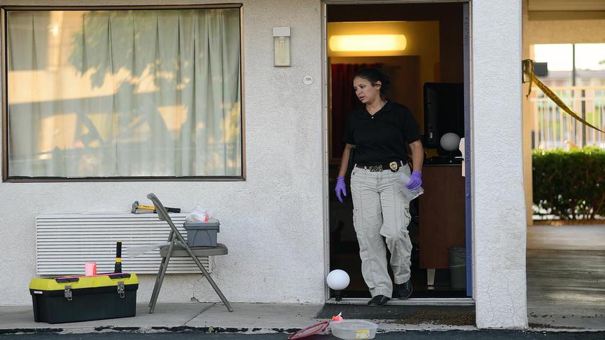 
An Albuquerque police officer collects evidence Wednesday after a man was killed and another injured during what police say was an altercation between the two late Tuesday at a Motel 6 in Albuquerque, N.M. 
