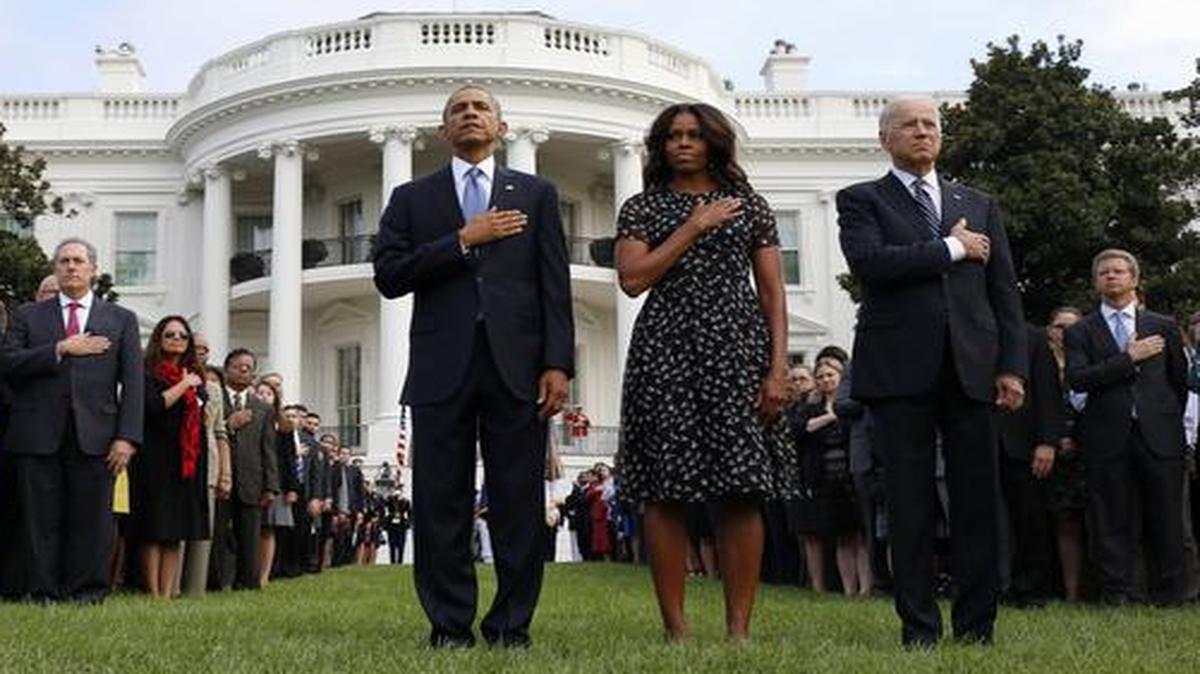 
President Barack Obama, first lady Michelle Obama, Vice President Joe Biden, and others put their hands on their hearts during the playing of Taps on the South Lawn of the White House in Washington, Thursday, Sept. 11, 2014, as they mark the 13th anniversary of the 9/11 attacks.
