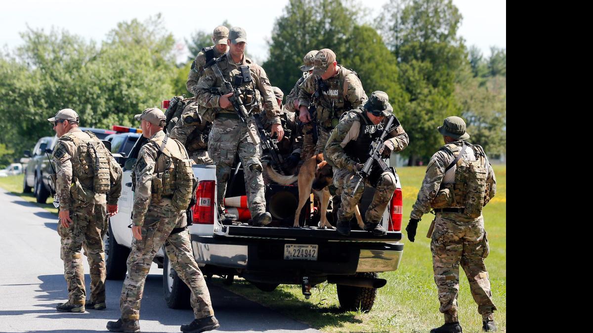 
Law enforcement officers get off a truck after searching a wooded area Sunday in Schuyler Falls, N.Y. 
