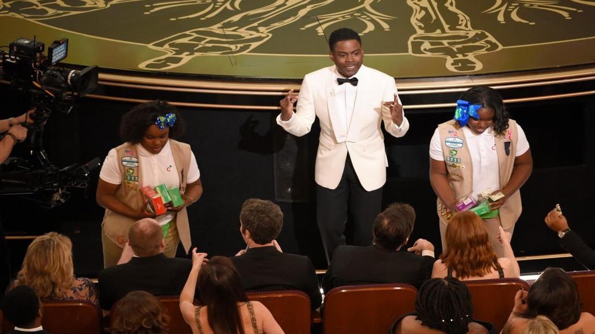 Host Chris Rock sells Girl Scout cookies in the audience at the Oscars on Sunday, Feb. 28, 2016, at the Dolby Theatre in Los Angeles.
