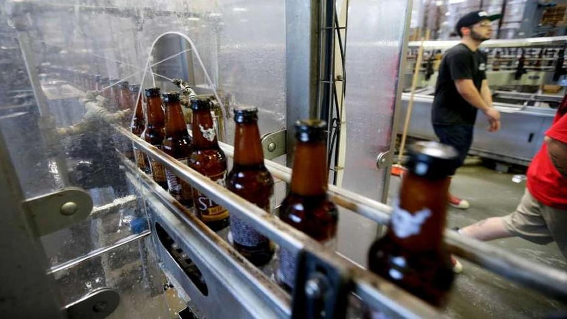 In this 2015 photo, bottles of beer are cleaned using recycled non-potable water during the bottling process at Stone Brewing Co. in Escondido, Calif.