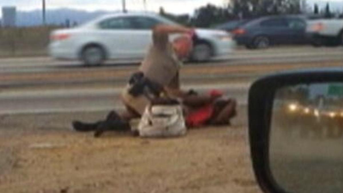 
A California Highway Patrol officer straddles a woman while punching her next to a Los Angeles freeway
