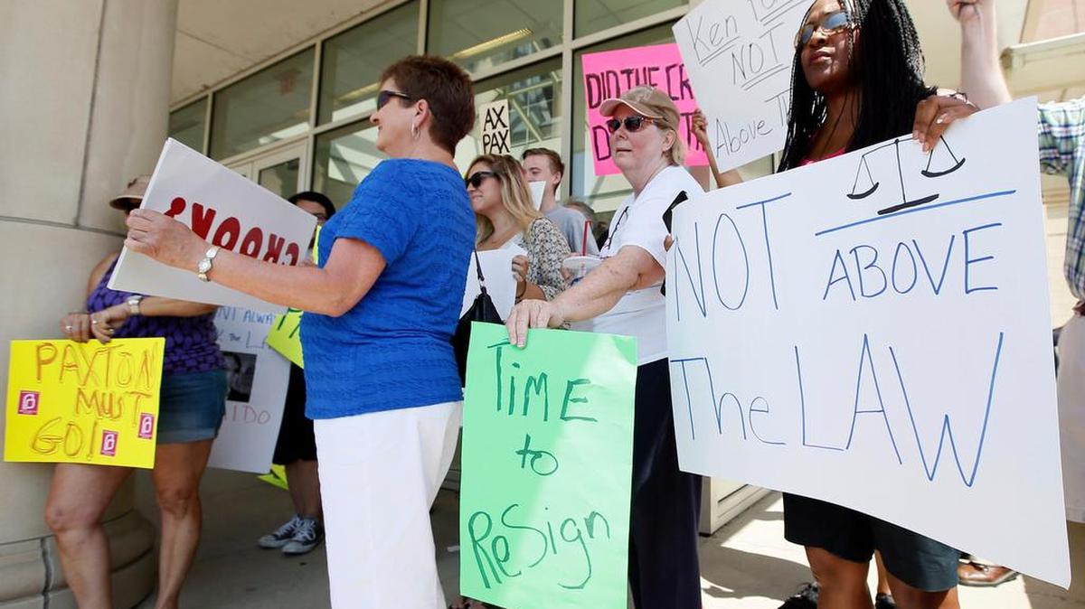 
Protesters against Texas Attorney General Ken Paxton stand outside the Collin County Courthouse, Monday in Plano, Texas.
